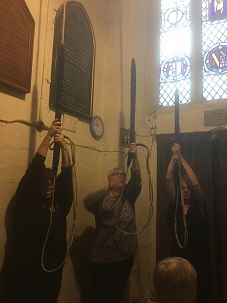 three members prepare to ring the bells
