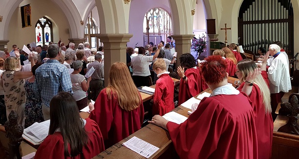 view of the full church from the choir, the choir is dressed in red robes